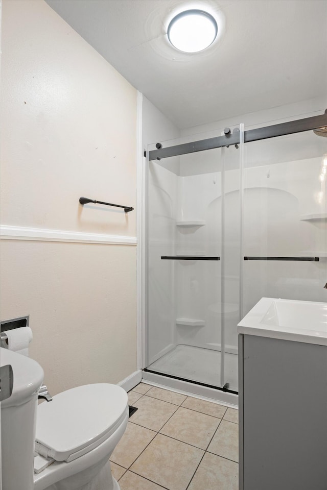 bathroom with tile patterned floors, vanity, toilet, and walk in shower