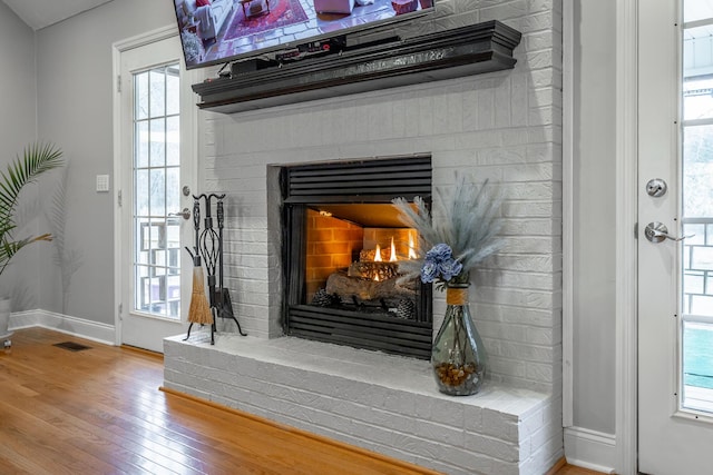 details featuring hardwood / wood-style floors and a brick fireplace