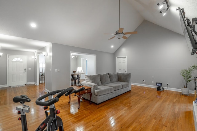 living room with light hardwood / wood-style floors, high vaulted ceiling, and ceiling fan