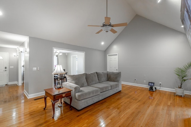 living room with high vaulted ceiling, ceiling fan, and light wood-type flooring