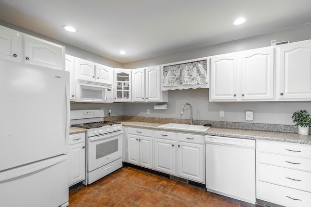 kitchen with sink, white appliances, and white cabinets