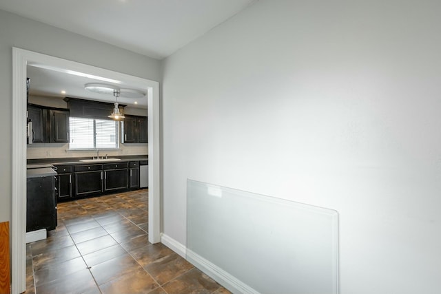 hallway with dark tile patterned floors and sink