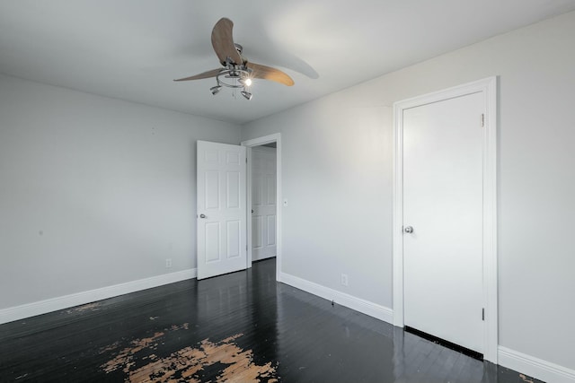 empty room with ceiling fan and dark hardwood / wood-style flooring