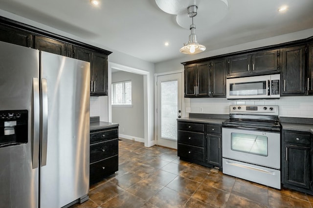 kitchen with electric range, backsplash, stainless steel fridge, and hanging light fixtures