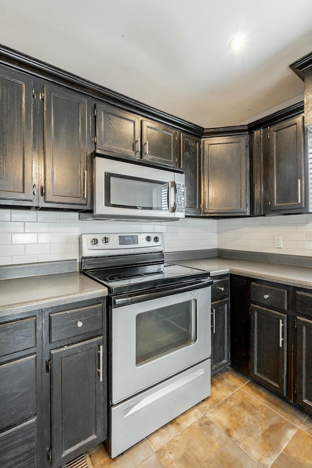 kitchen featuring backsplash, light tile patterned floors, and appliances with stainless steel finishes