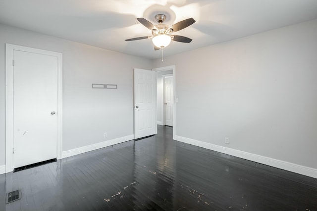 empty room with ceiling fan and dark hardwood / wood-style flooring