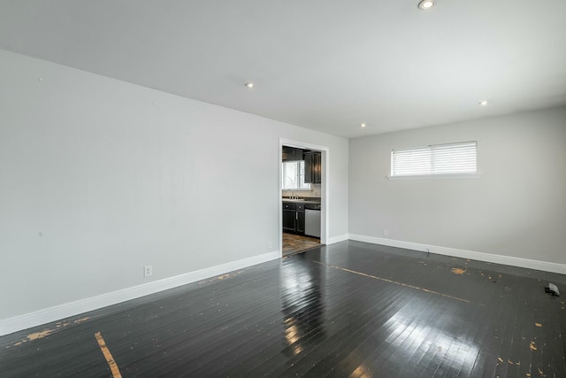 spare room featuring sink and dark wood-type flooring