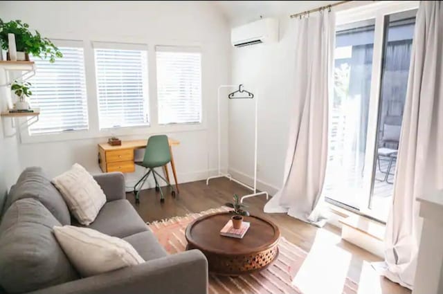 living area with dark hardwood / wood-style floors and a wall mounted AC