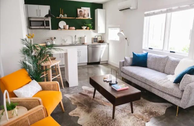 living room featuring concrete floors, a wall mounted AC, and sink