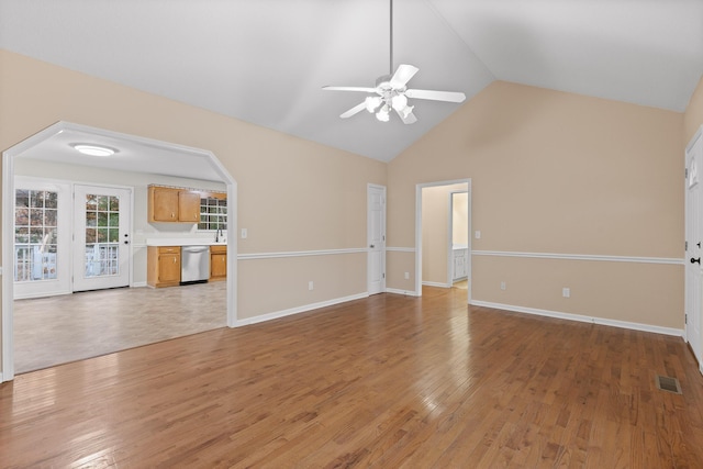 unfurnished living room featuring vaulted ceiling, light hardwood / wood-style flooring, and ceiling fan