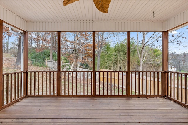 unfurnished sunroom featuring ceiling fan and a wealth of natural light