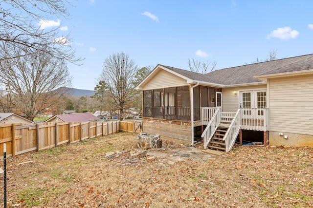 back of property with a sunroom and a deck with mountain view