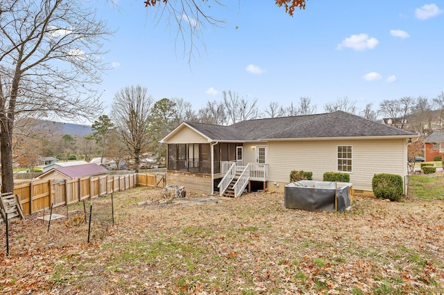 back of property with a mountain view and a sunroom