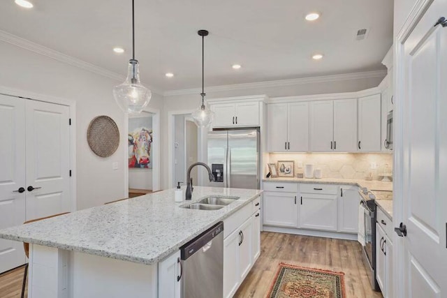 kitchen with a kitchen island with sink, sink, white cabinets, and stainless steel appliances