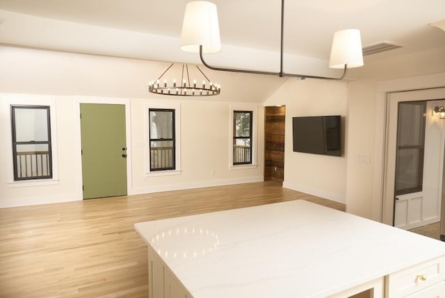 unfurnished bedroom featuring an inviting chandelier and light hardwood / wood-style floors