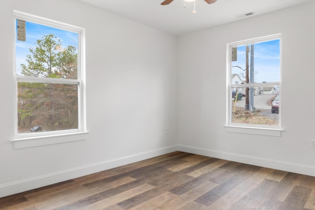 spare room with ceiling fan, dark hardwood / wood-style flooring, and a wealth of natural light