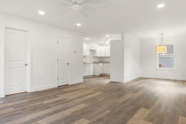 unfurnished living room with ceiling fan and dark hardwood / wood-style flooring