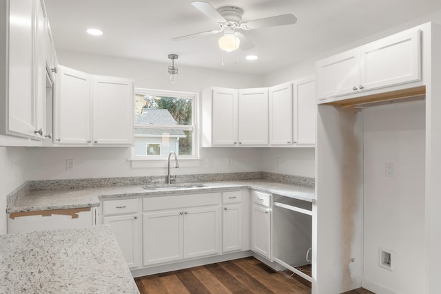 kitchen with ceiling fan, sink, dark wood-type flooring, light stone counters, and white cabinets