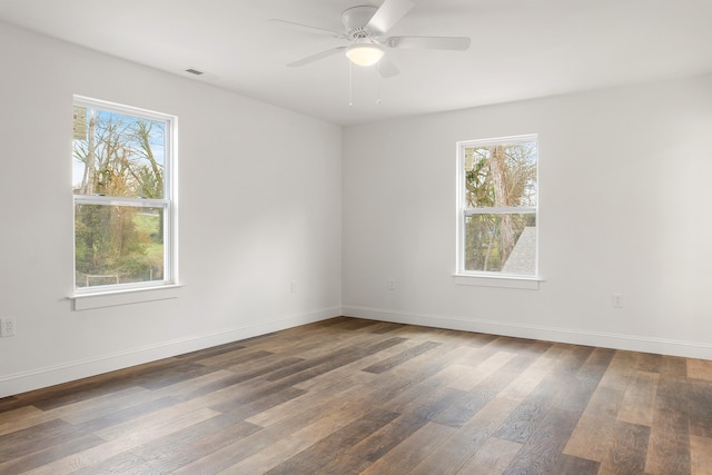 spare room featuring a wealth of natural light, dark wood-type flooring, and ceiling fan