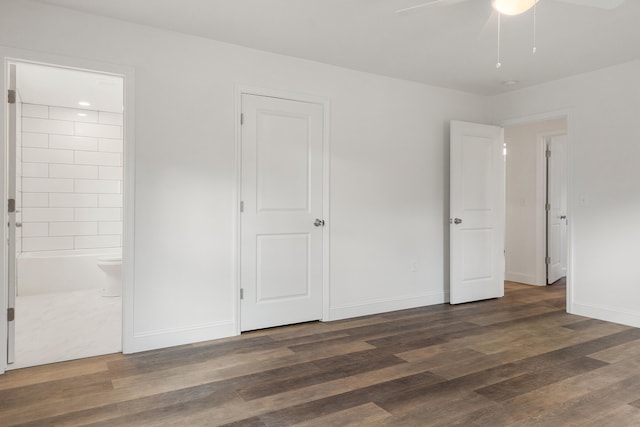 unfurnished bedroom featuring ensuite bath, ceiling fan, and dark hardwood / wood-style floors