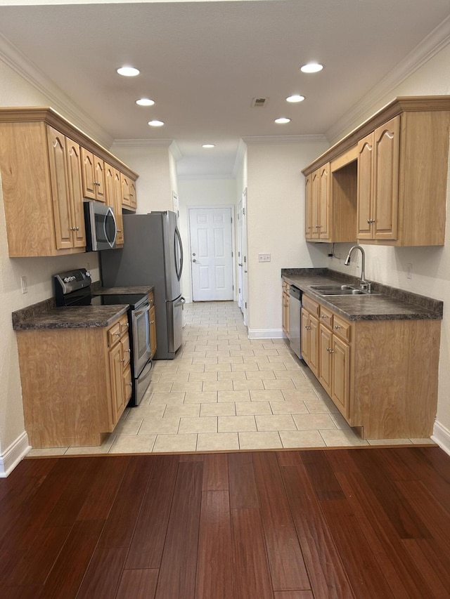 kitchen featuring sink, ornamental molding, stainless steel appliances, and light hardwood / wood-style flooring