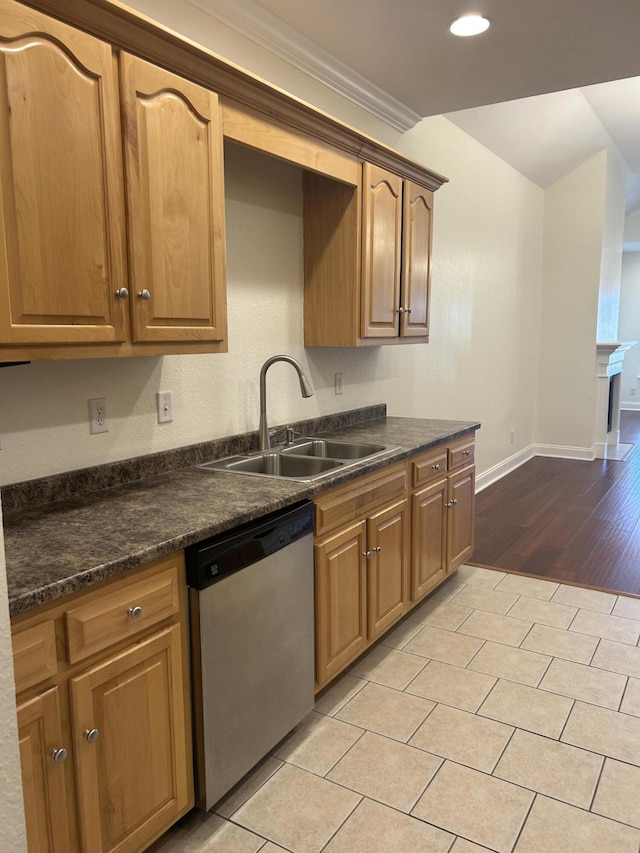 kitchen with dishwasher, light wood-type flooring, dark stone countertops, and sink