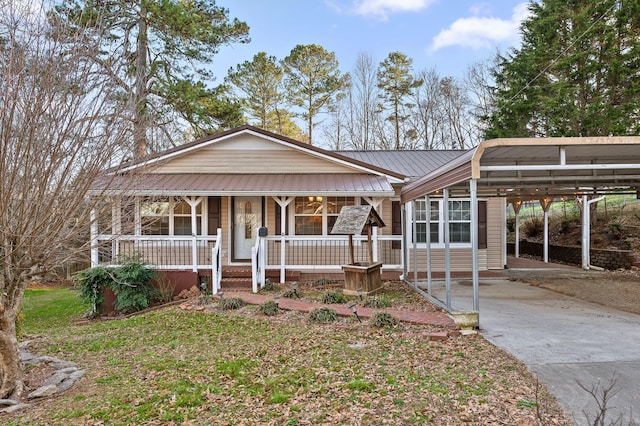 view of front of home featuring driveway, metal roof, a porch, and a carport