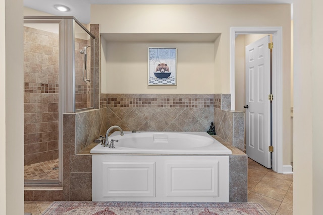 bathroom featuring tile patterned flooring and shower with separate bathtub