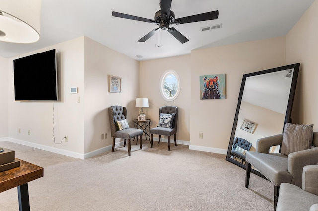 living area with light colored carpet and ceiling fan