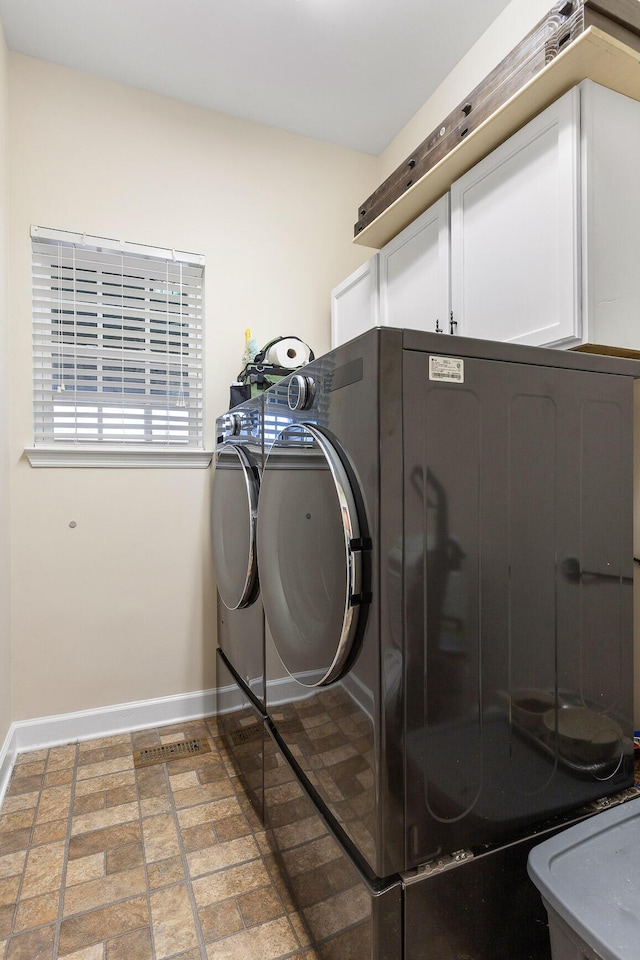 washroom with cabinets and washing machine and dryer