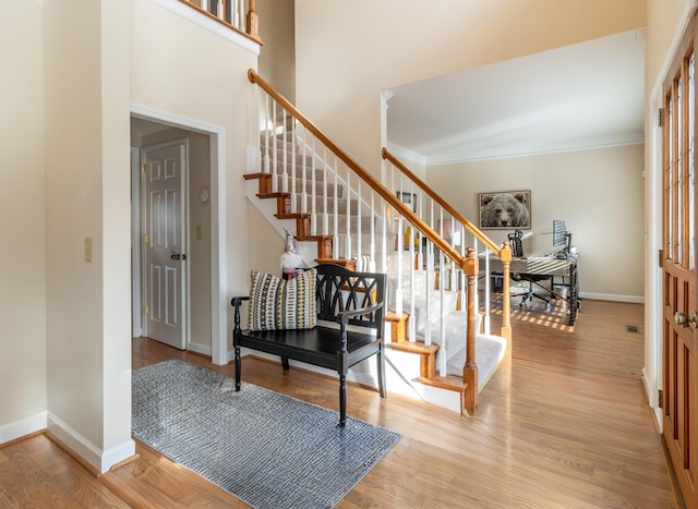 foyer entrance featuring light hardwood / wood-style floors and crown molding