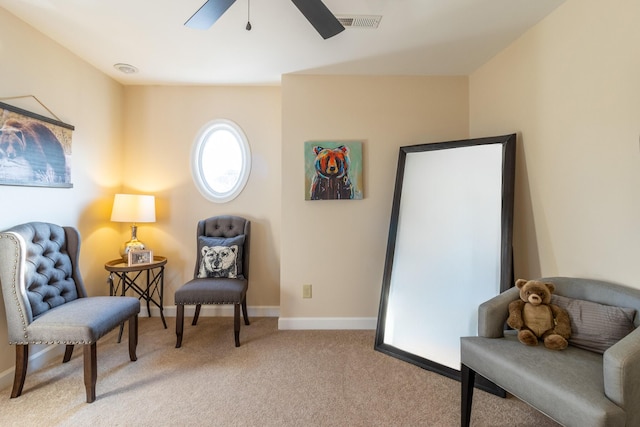 sitting room featuring light colored carpet and ceiling fan