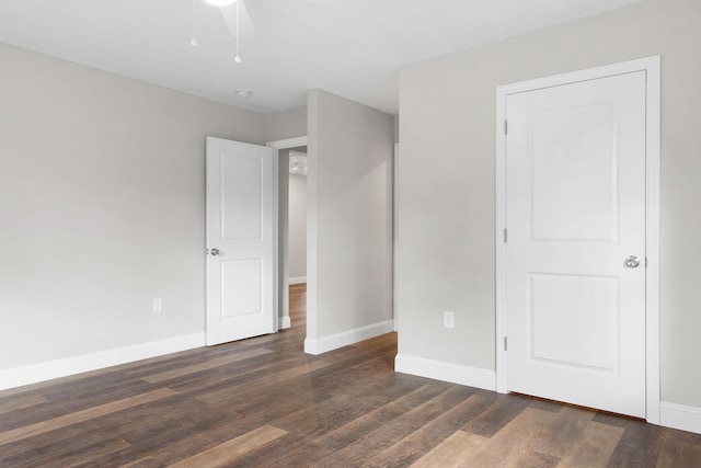 unfurnished bedroom featuring ceiling fan and dark wood-type flooring