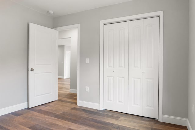 unfurnished bedroom featuring a closet and dark hardwood / wood-style floors