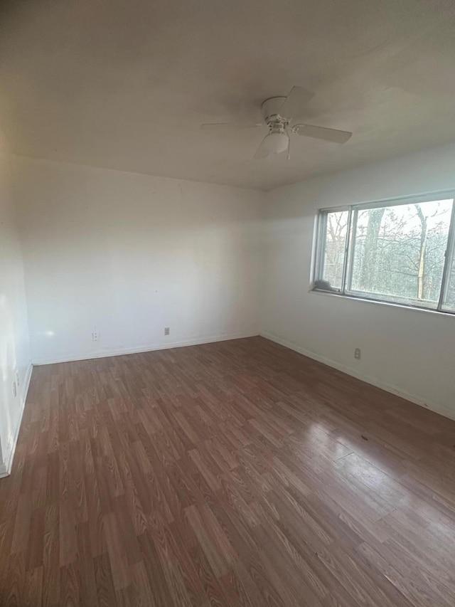 spare room with ceiling fan and dark wood-type flooring