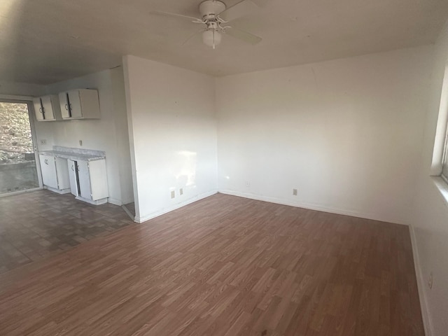 unfurnished living room with ceiling fan and dark wood-type flooring