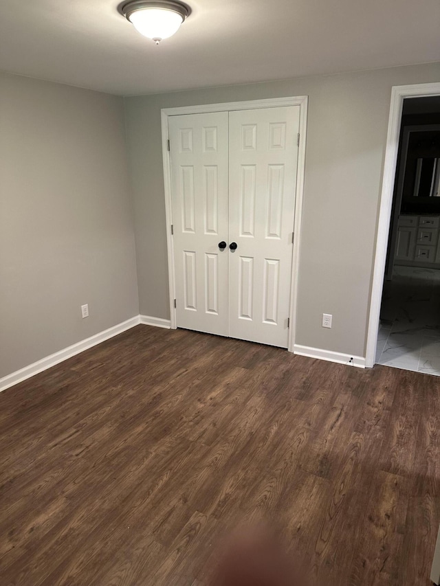 unfurnished bedroom featuring dark hardwood / wood-style floors and a closet