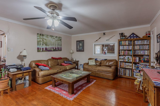 living room featuring hardwood / wood-style floors, ceiling fan, and crown molding