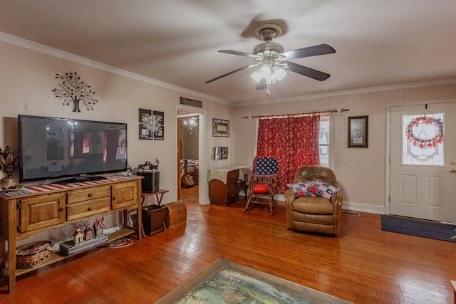 living room with ceiling fan, wood-type flooring, and ornamental molding