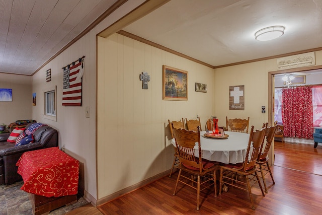 dining space featuring hardwood / wood-style floors and crown molding