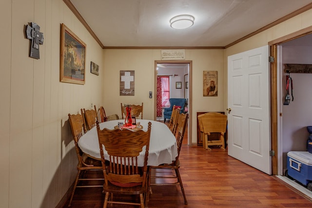 dining space featuring wood-type flooring and ornamental molding