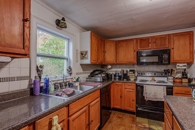 kitchen featuring decorative backsplash, light wood-type flooring, ornamental molding, sink, and black appliances