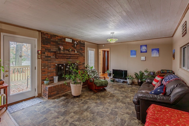 living room with a fireplace, wood ceiling, and ornamental molding