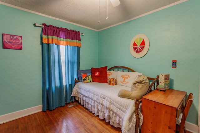 bedroom featuring wood-type flooring, a textured ceiling, ceiling fan, and ornamental molding