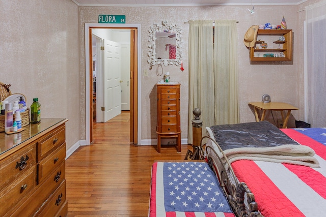 bedroom with wood-type flooring and crown molding