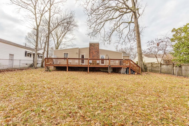 rear view of property with a lawn and a wooden deck