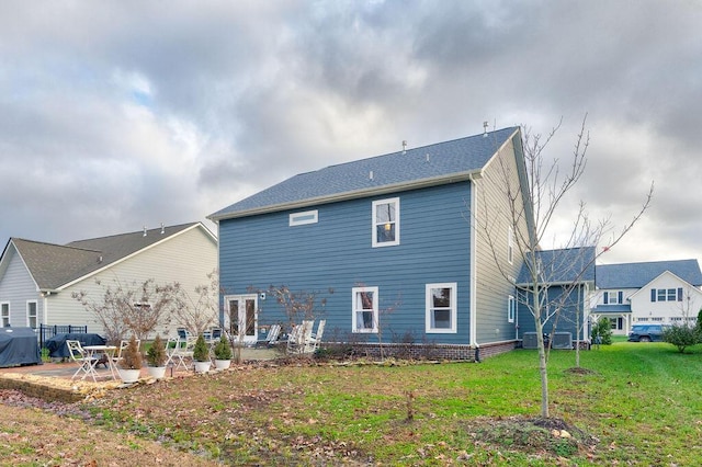 rear view of property featuring a lawn, a patio area, and cooling unit