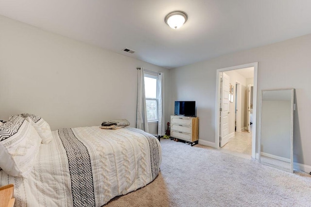 bedroom featuring light colored carpet and connected bathroom