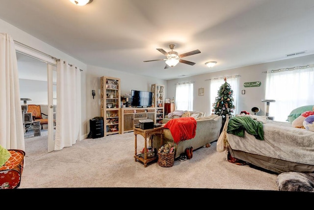 carpeted bedroom featuring ceiling fan and multiple windows