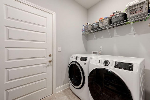 laundry room featuring washing machine and dryer and light tile patterned floors